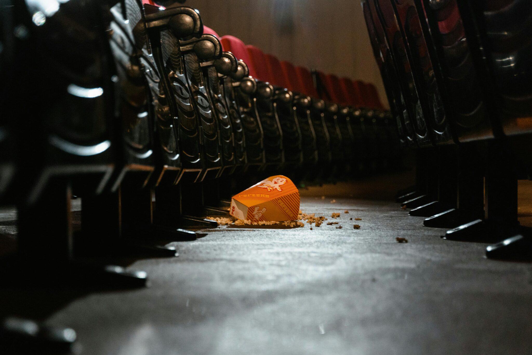 Popcorn-kulho kaatuneena elokuvateatterin lattialla.